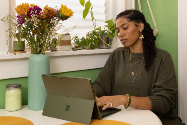 a woman sitting at a table using a laptop computer