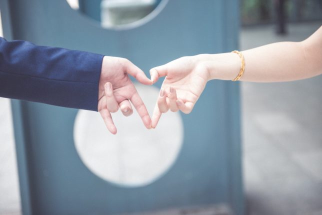 couple making heart shape of the law of attraction